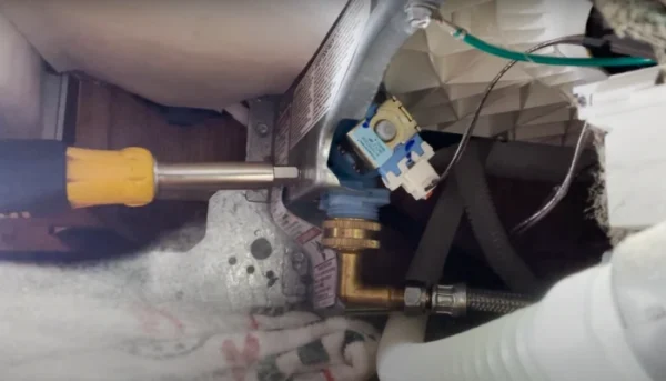 Unscrewing the water inlet valve.