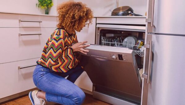 A women fixing her dishwasher.