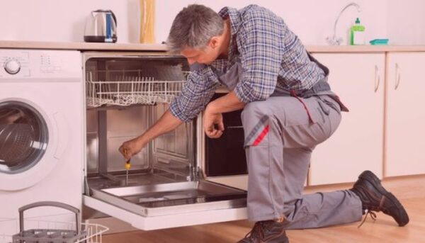 Appliance repair professional repairing the dishwasher.